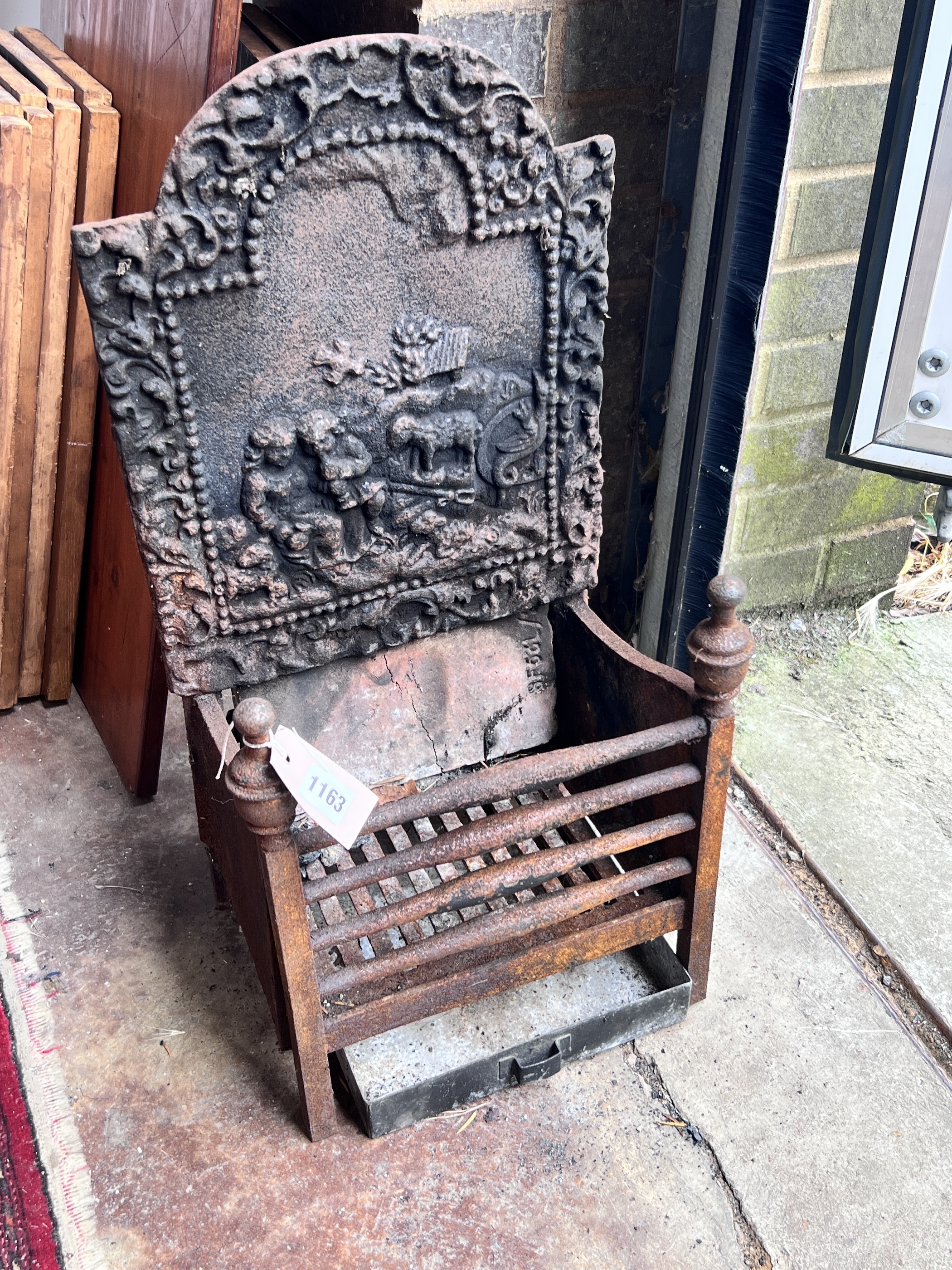 A small cast iron fire grate, width 33cm, depth 23cm, height 66cm